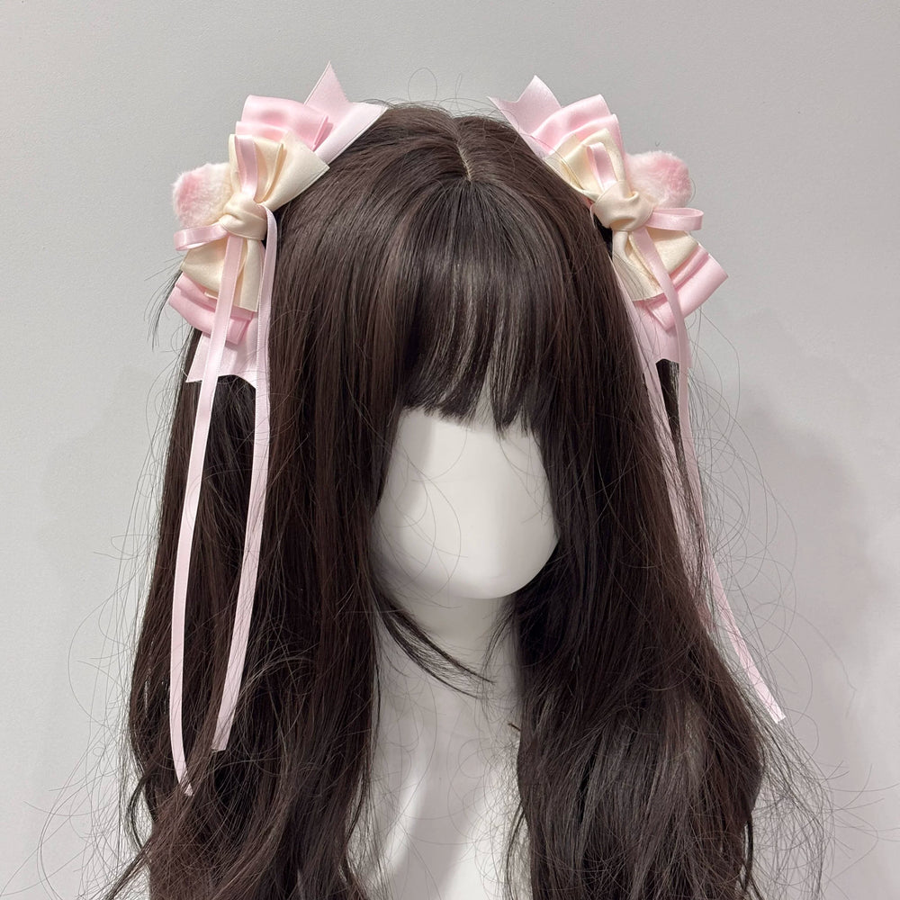 Pink and cream layered bow side hair clips with trailing ribbons on a mannequin