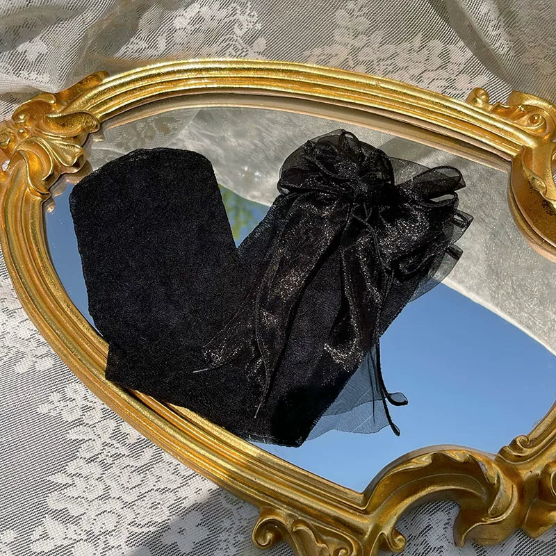 Black floral socks with a sheer bow detail shown in a flat-lay product view