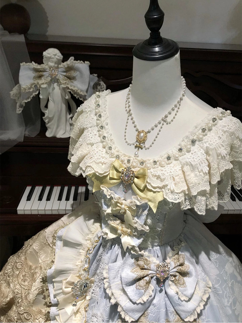 Pale blue and ivory Lolita skirt set with layered lace and bows on a mannequin