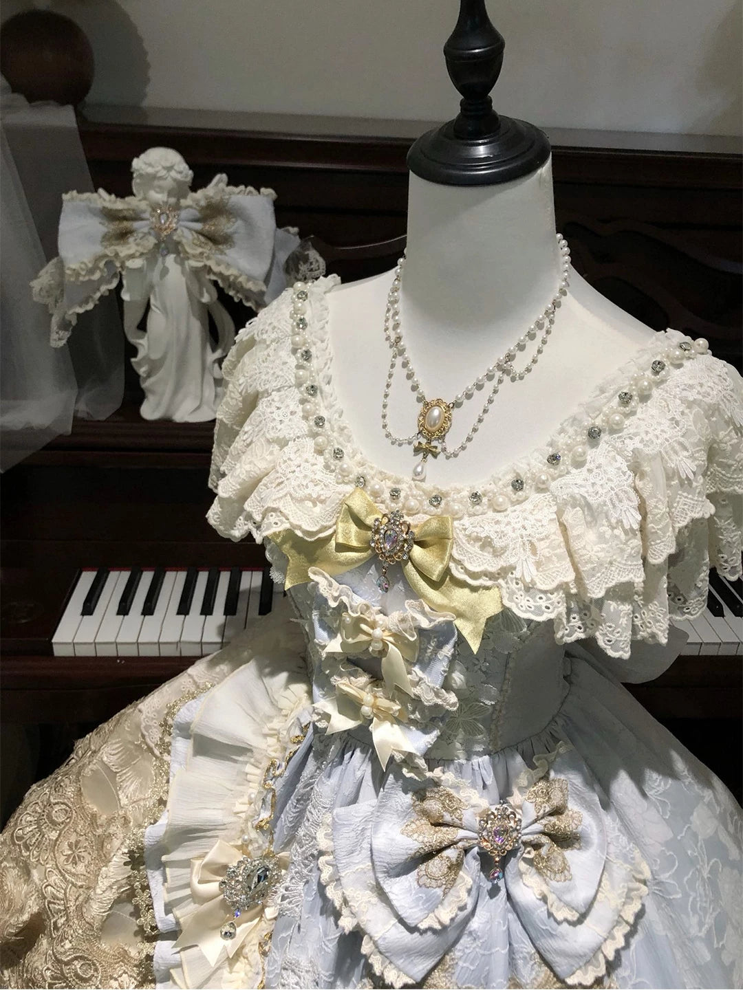 Pale blue and ivory Lolita skirt set with layered lace and bows on a mannequin