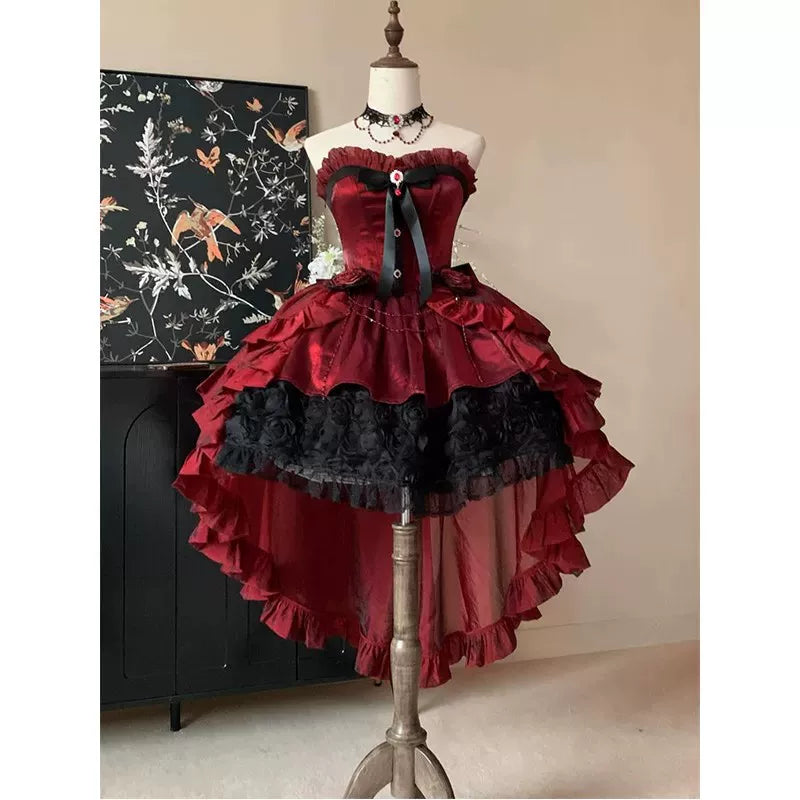 Red and black jumper skirt with bow, rose accents and a long ruffled train on a mannequin.