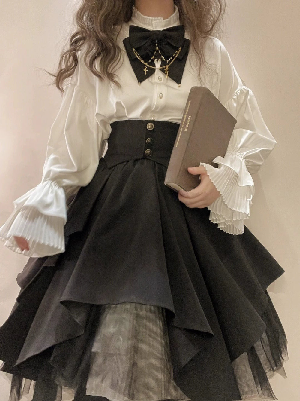 Creamy black-and-white blouse and skirt set with pleated balloon sleeves, waist panel and bow tie.