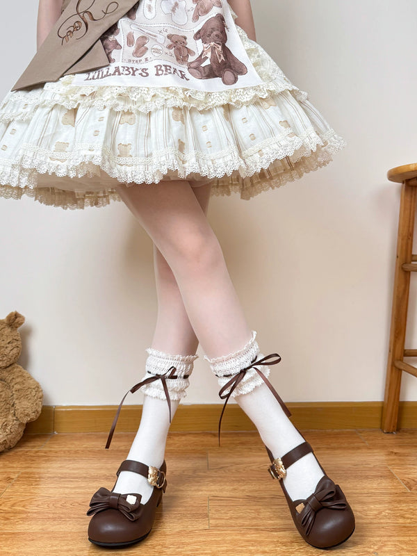 White socks with lace cuffs and brown ribbon ties worn with brown bow shoes.