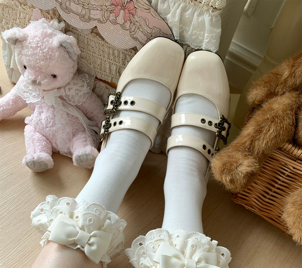 Lace-trimmed socks with bows in multiple colours arranged beside red shoes on a wooden floor.