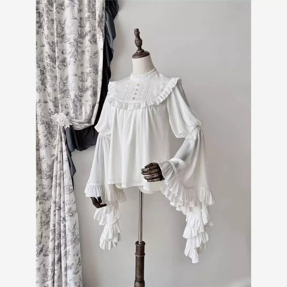 Pleated ruffle blouse with a high collar and long flared sleeves shown on a mannequin.