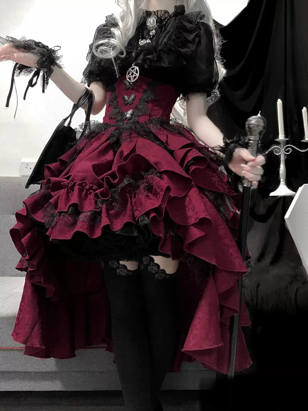 Black blouse and red suspender skirt set with layered ruffles and butterfly accents