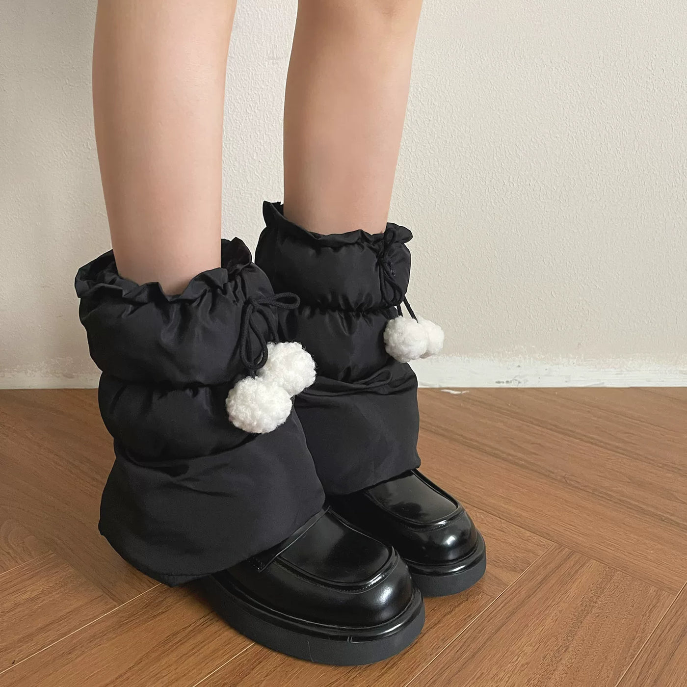Sock Noble black plush sock covers with white pom-pom ties worn with black shoes