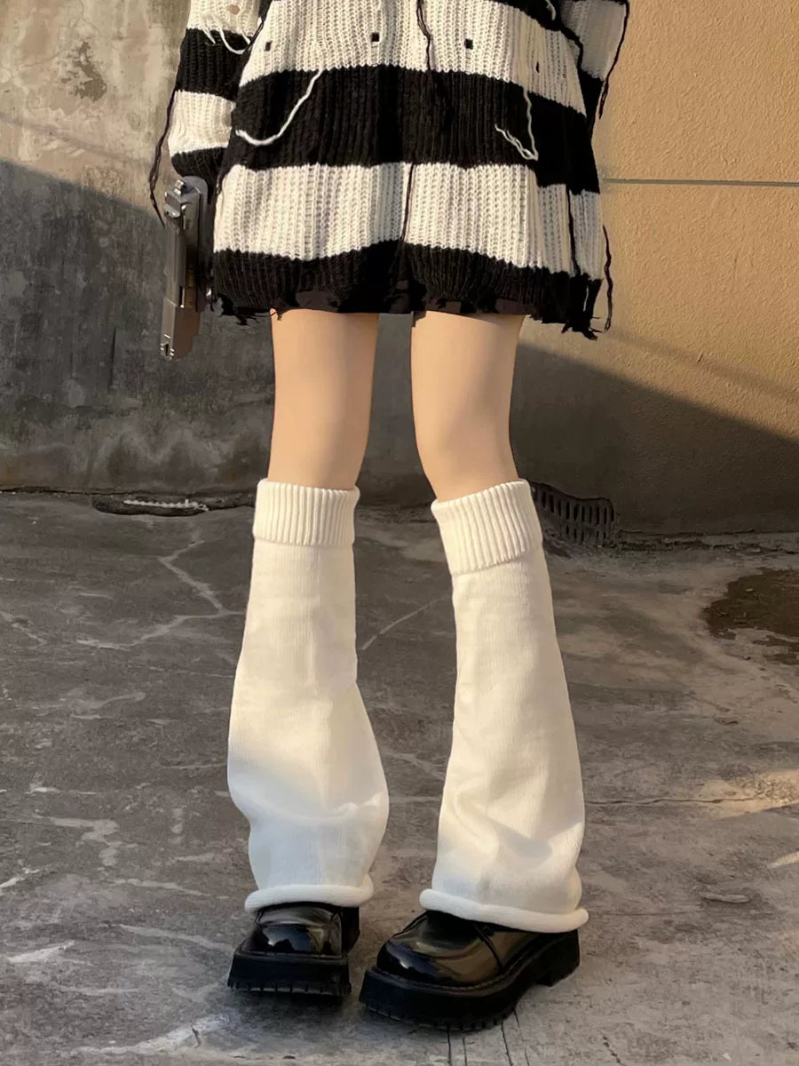 Black and white flared knit leg warmers worn over platform shoes