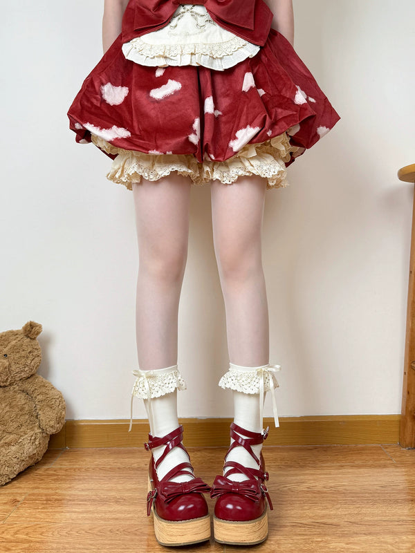 Beige lace socks with scalloped cuffs styled beneath a red Lolita skirt