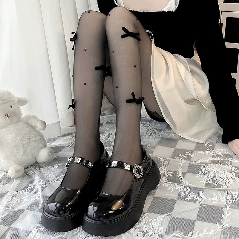 Model wearing white pearl-and-bow tights with white Mary Jane shoes