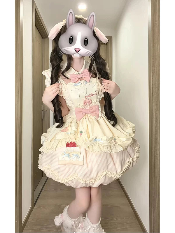 Pink-and-cream Lolita skirt set with ruffles, bows, apron, and cake motifs shown on a model