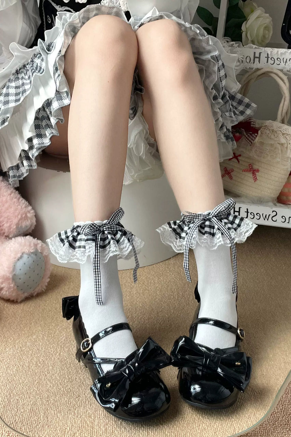 White socks with black gingham ruffle cuffs and bow ties styled with black patent shoes.
