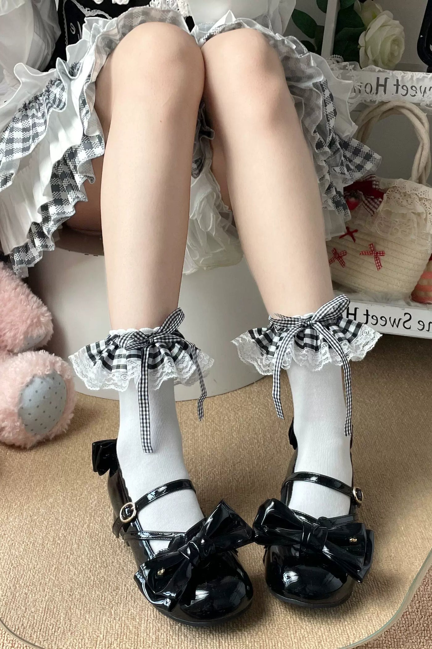 White socks with black gingham ruffle cuffs and bow ties styled with black patent shoes.