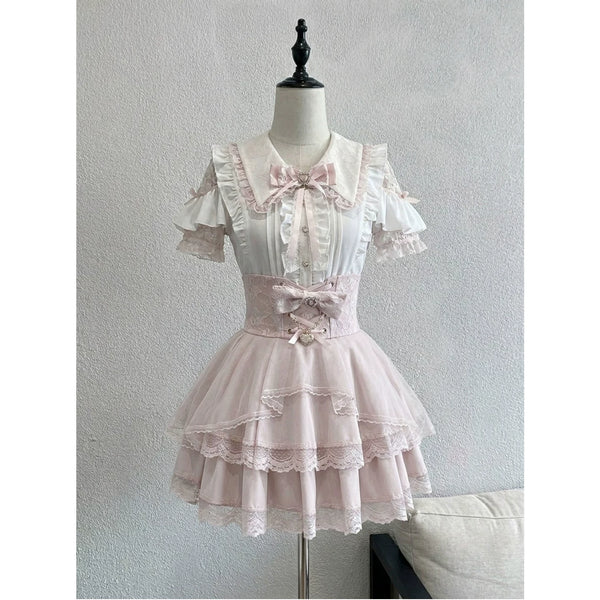 Creamy white short-sleeve blouse and pink high-waisted skirt set with lace trim.