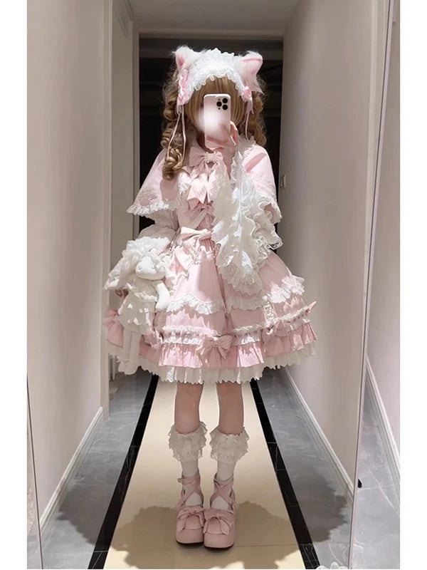 Pink Lolita styling with a lace cape, suspender dress and princess-sleeve blouse