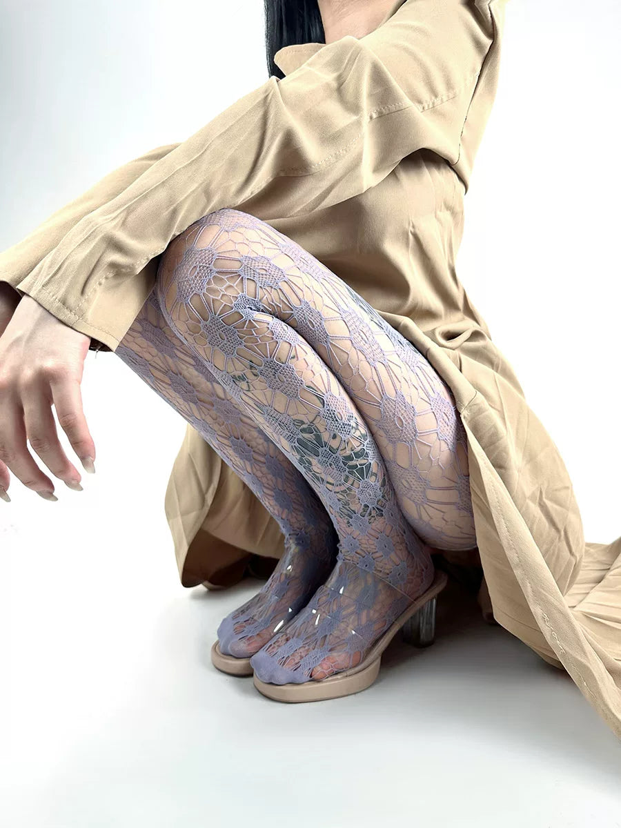 Purple openwork lace tights styled under a beige dress with heeled shoes