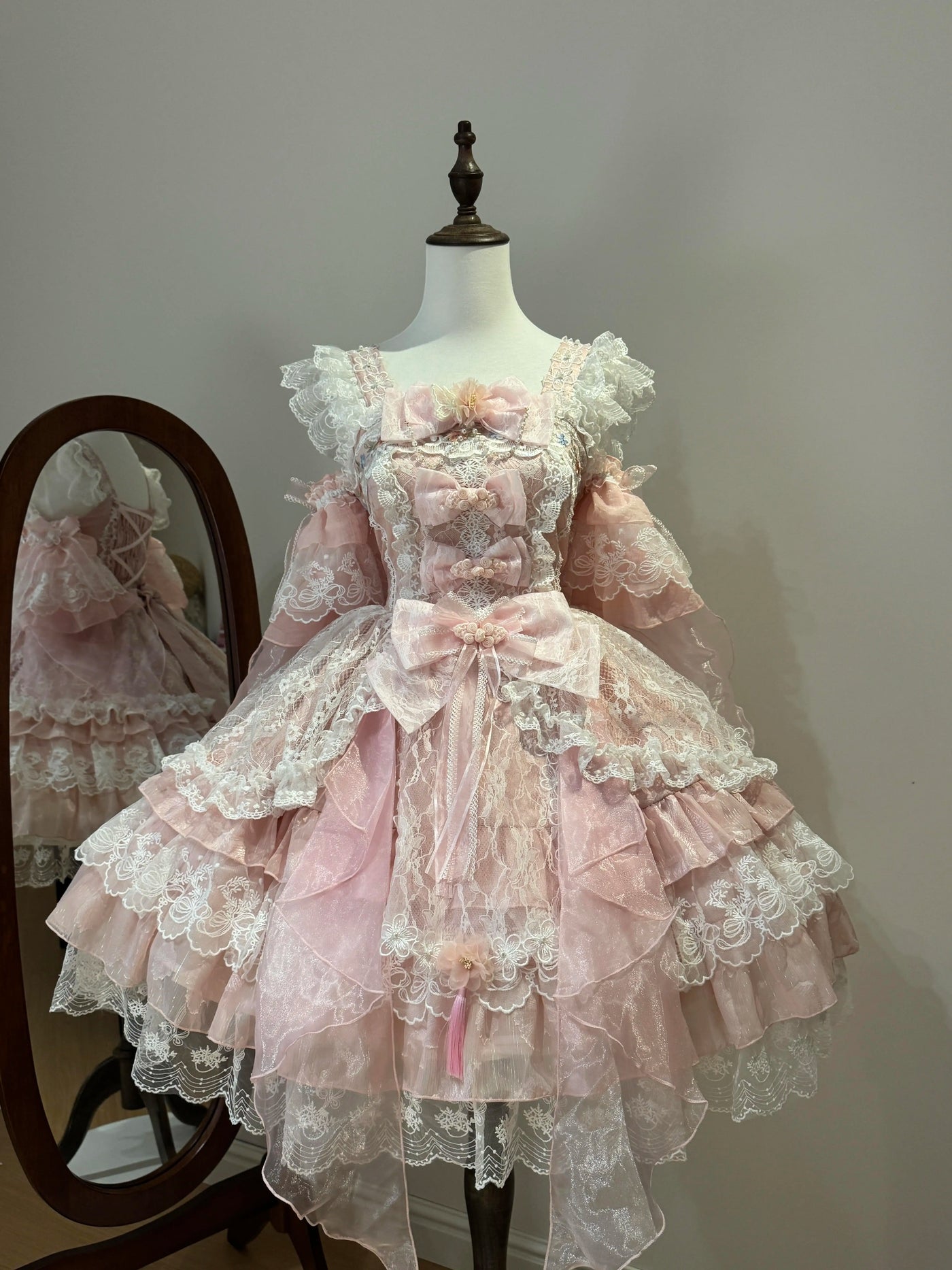 Creamy pink JSK suspender dress with lace bows on a mannequin