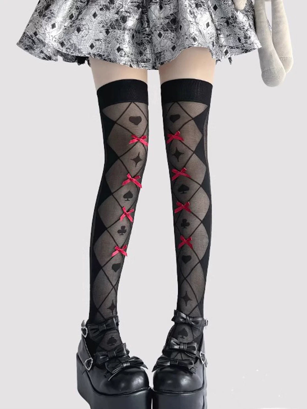 Black and white over-the-knee socks with card-suit motifs and red ribbon bows