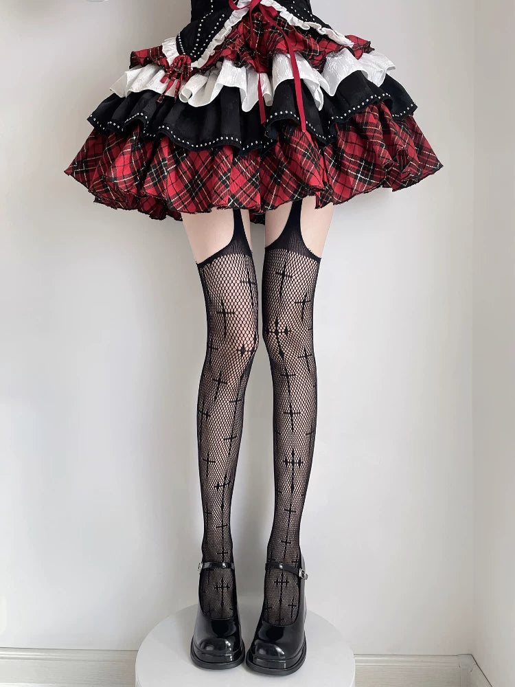 Black fishnet thigh-high stockings with repeated cross motifs styled with a red-and-black skirt and platform shoes.