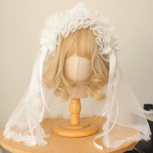 White lace veiled headwear and accessory pieces on mannequins