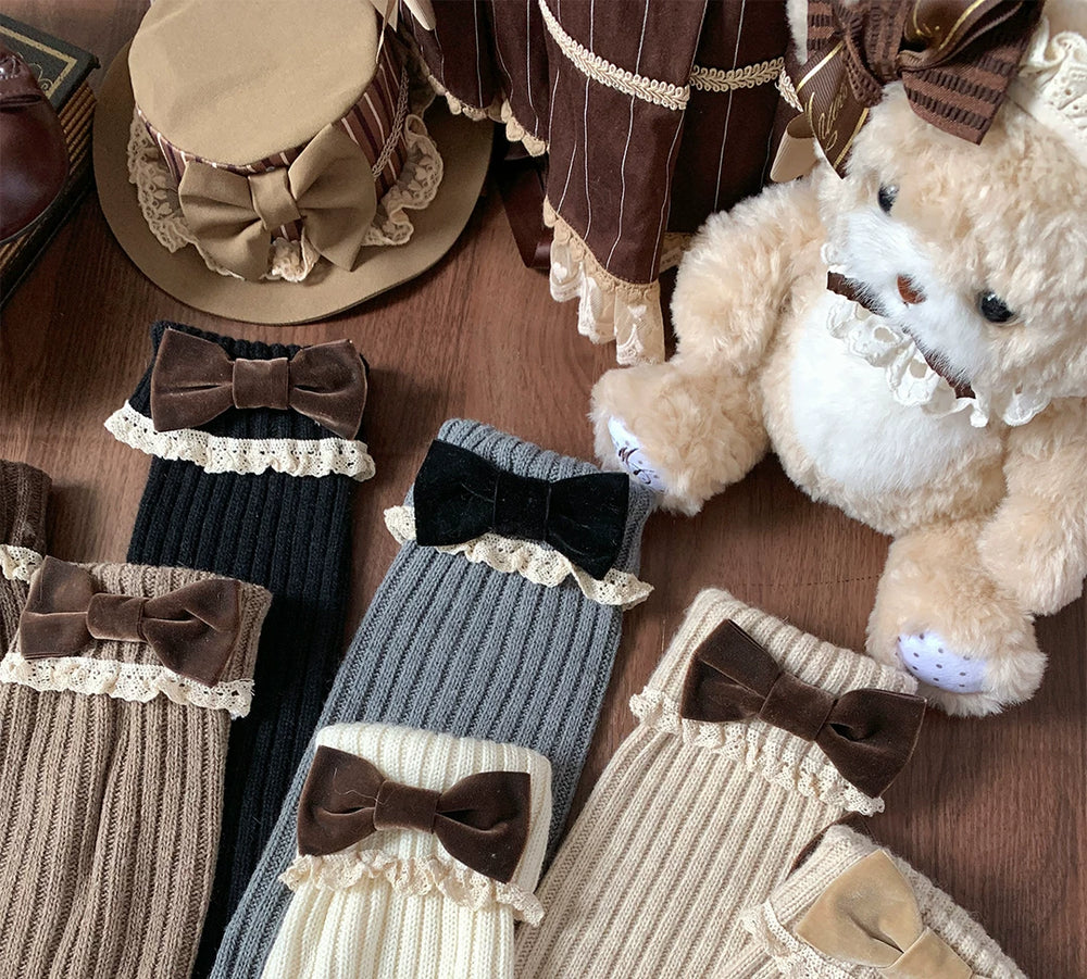 Knit mid-calf leg warmers with lace trim and bow accents