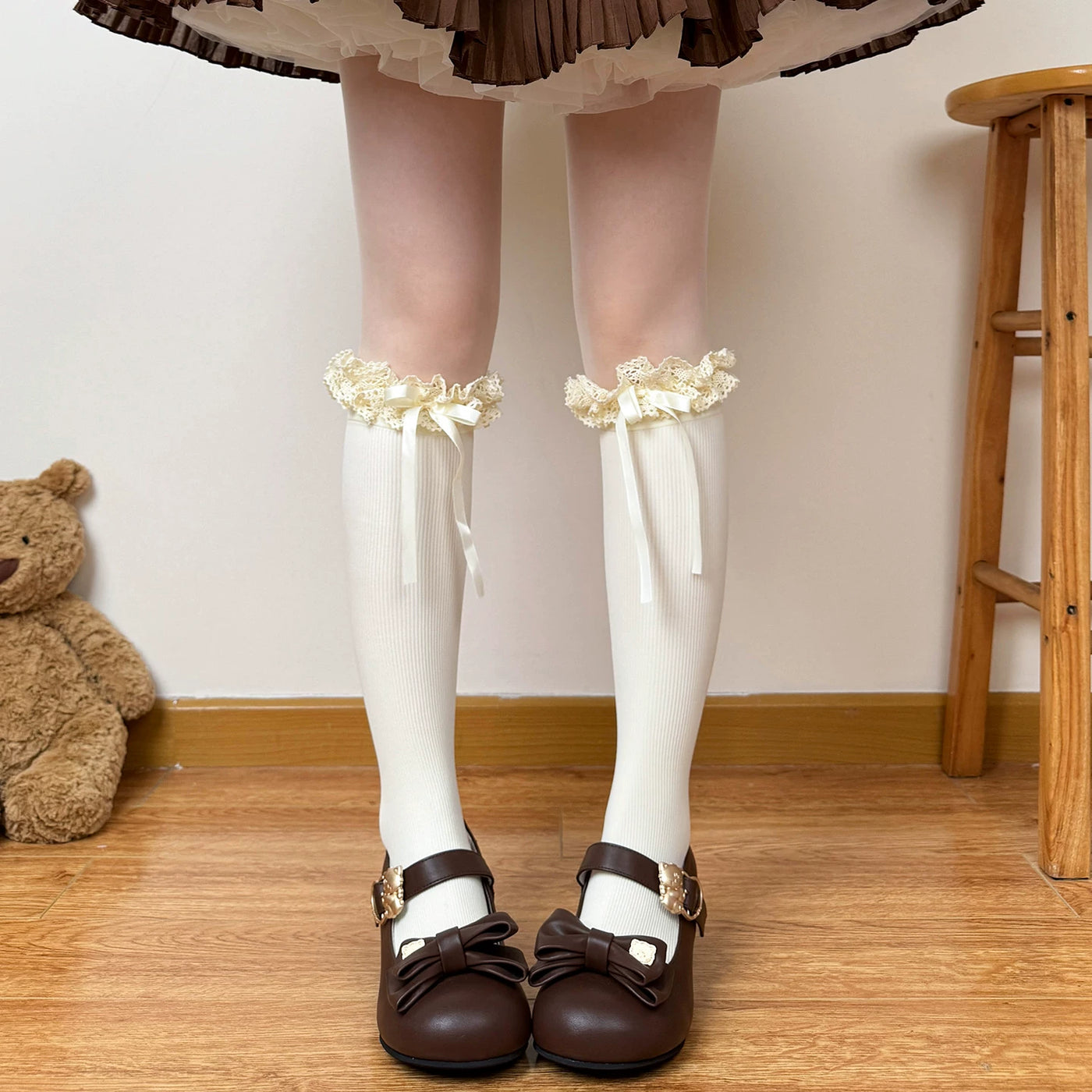 Ivory calf socks with lace cuffs and bows styled under a plaid skirt