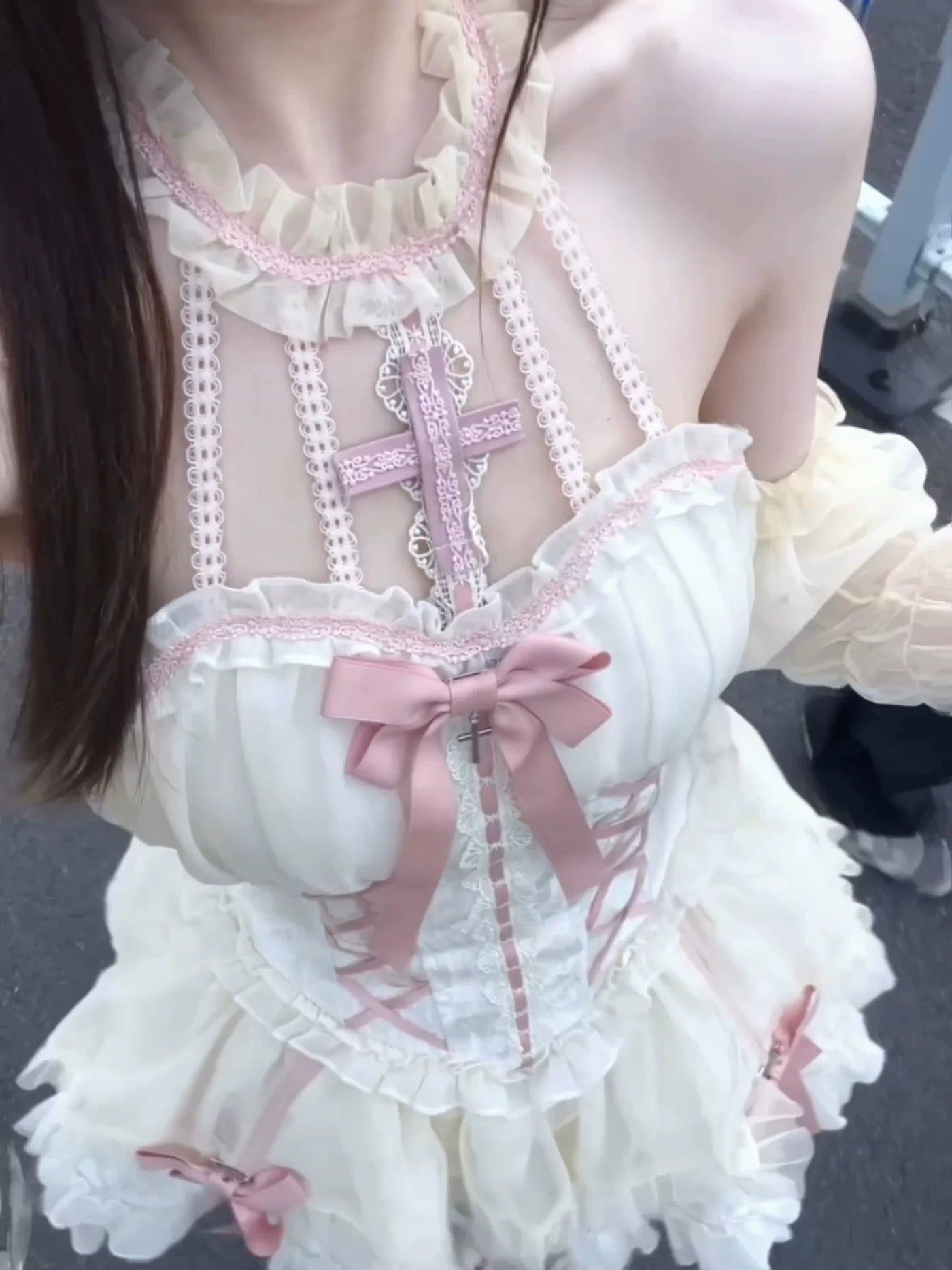 Pink and white Gothic Lolita dress with ruffles, bows and a cross ornament.