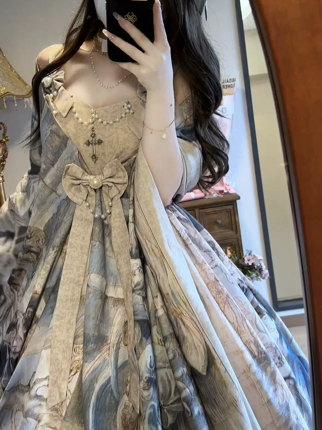 Model wearing a beige and grey vintage painting-style JSK dress with a shawl and large bow.