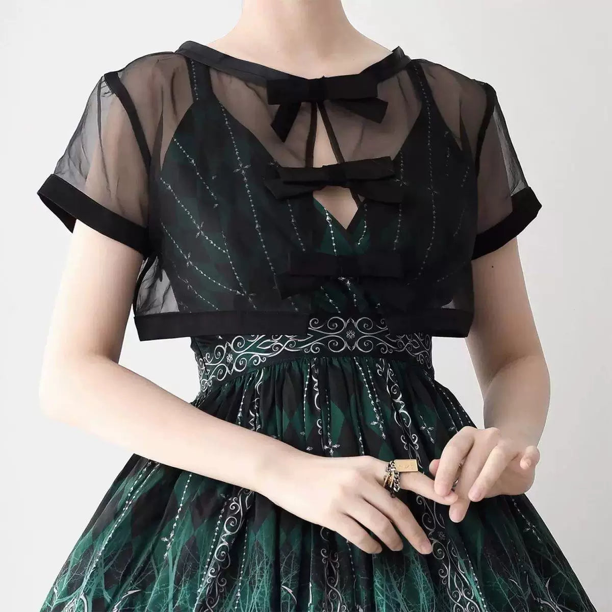 Black and white short-sleeve sheer layering blouses with bow details shown from the front and back.