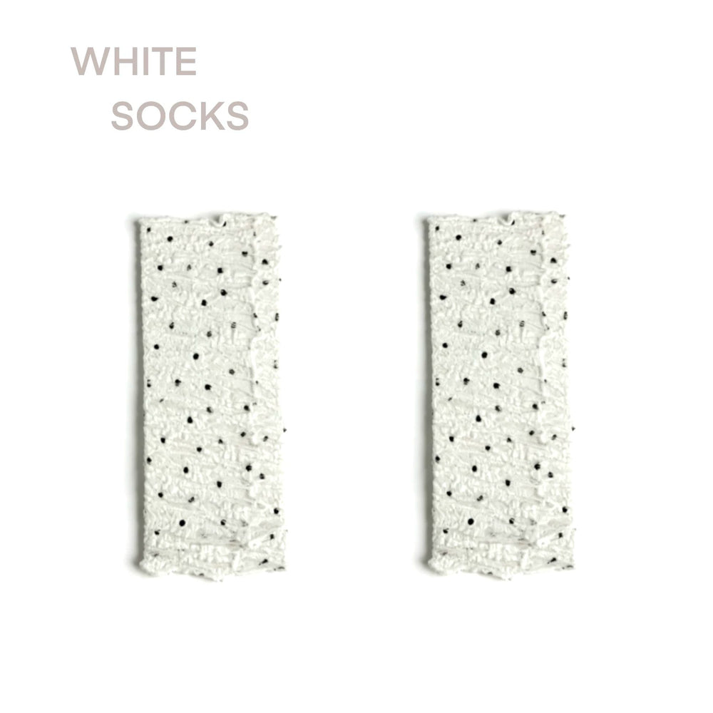 Sheer white mid-calf sock with black polka dots, ruched ankle, lace cuff, and satin ribbon tie