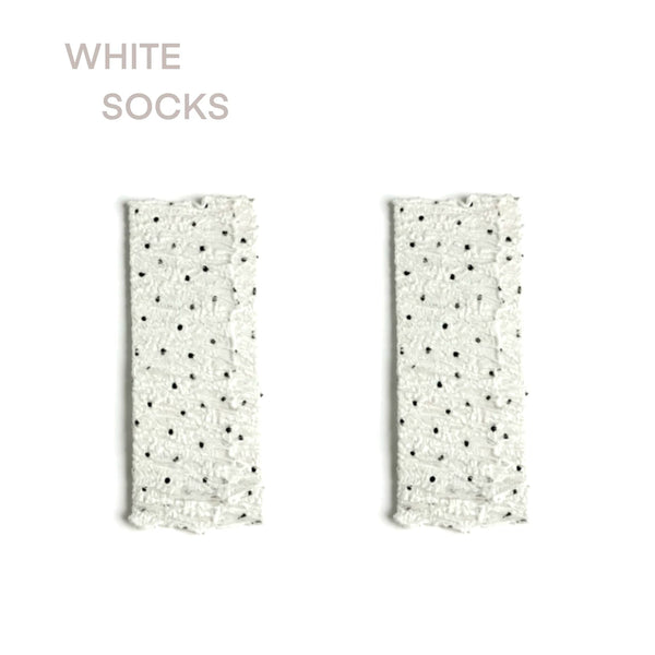 Sheer white mid-calf sock with black polka dots, ruched ankle, lace cuff, and satin ribbon tie