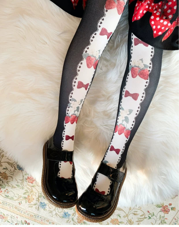 Black printed tights with a scalloped white panel, red strawberries and bow motifs.