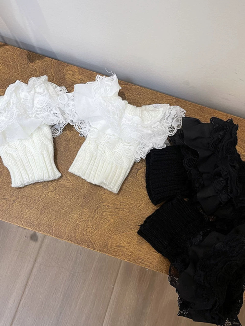 White lace-trimmed boot covers layered over brown boots with knit cuffs.