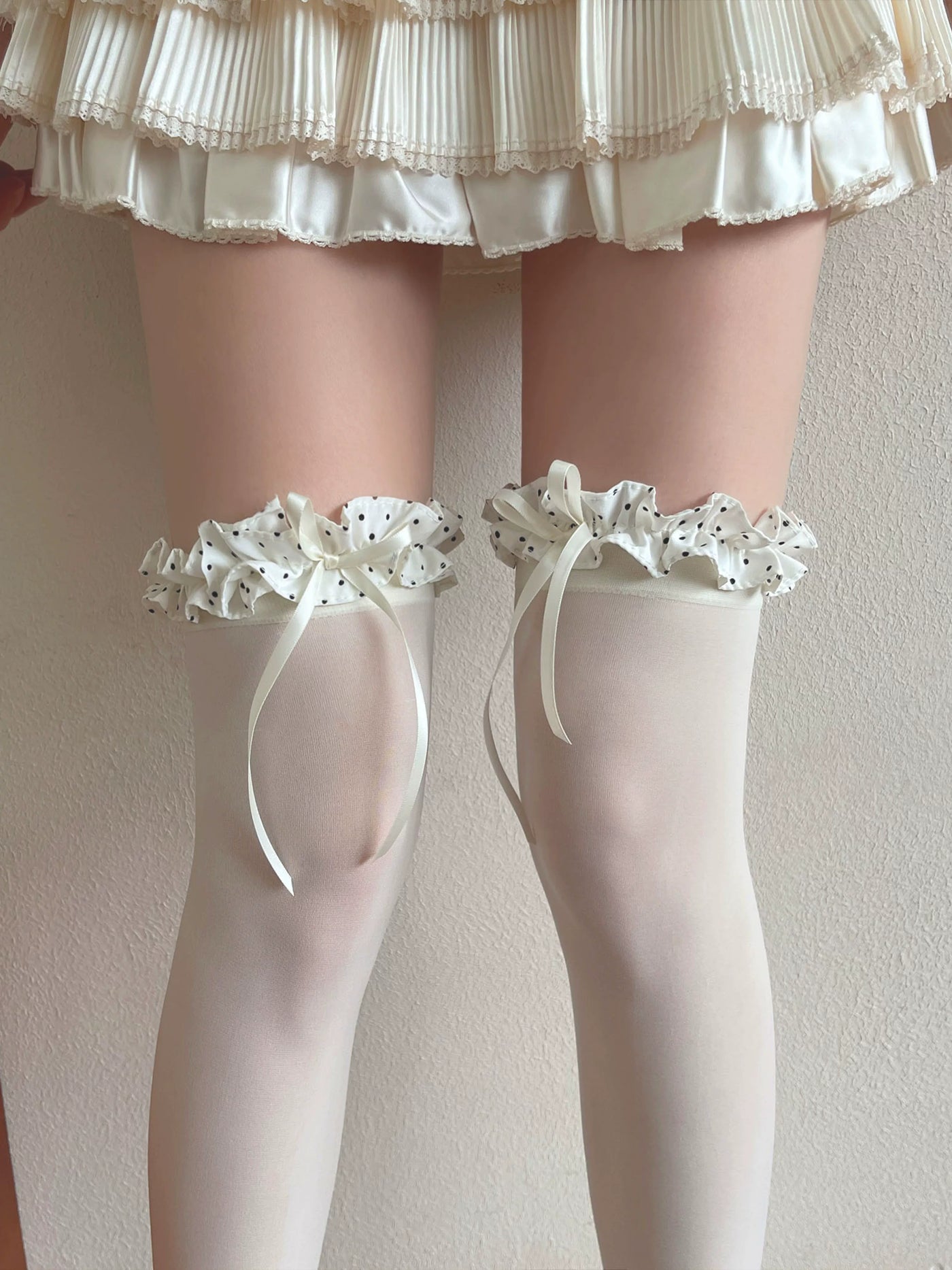 White velvet over-the-knee socks with polka-dot ruffled cuffs and long ribbon ties.