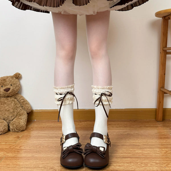 Model wearing brown over-the-knee socks with cream lace cuffs and dark ribbon ties.