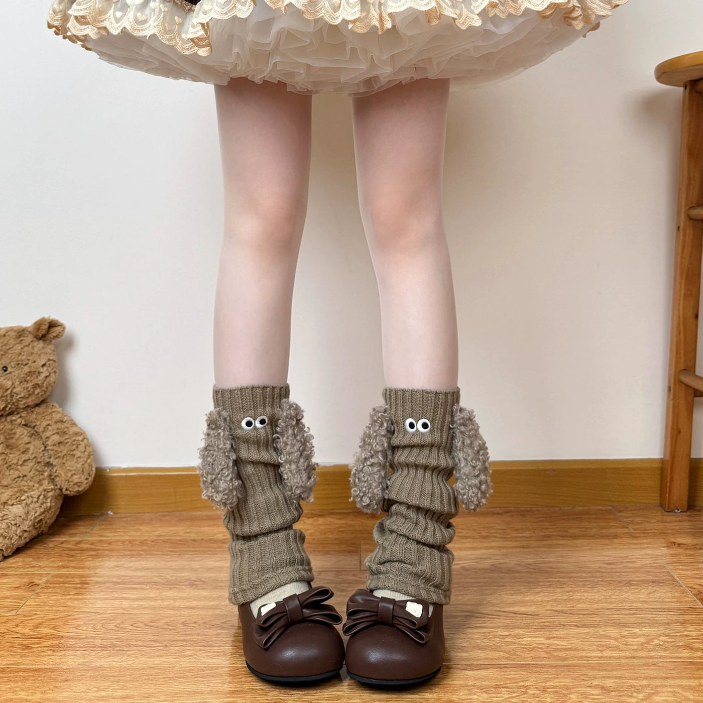 Off-white puppy-inspired ribbed leg warmers with round eye details and plush trim