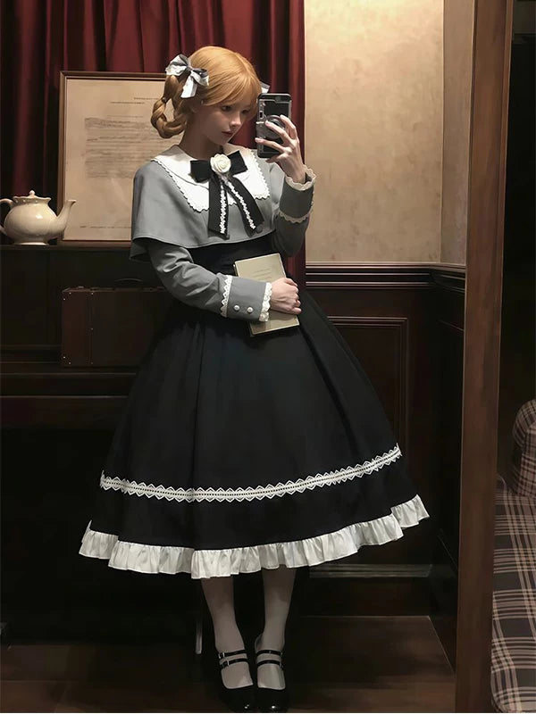 Front view of Gothic Lolita two-piece set with grey bodice, black lace-trimmed midi skirt, oversized white Peter Pan collar with black edging, and large black bow with white floral center at neckline, paired with white knee-high socks and black Mary Jane shoes.