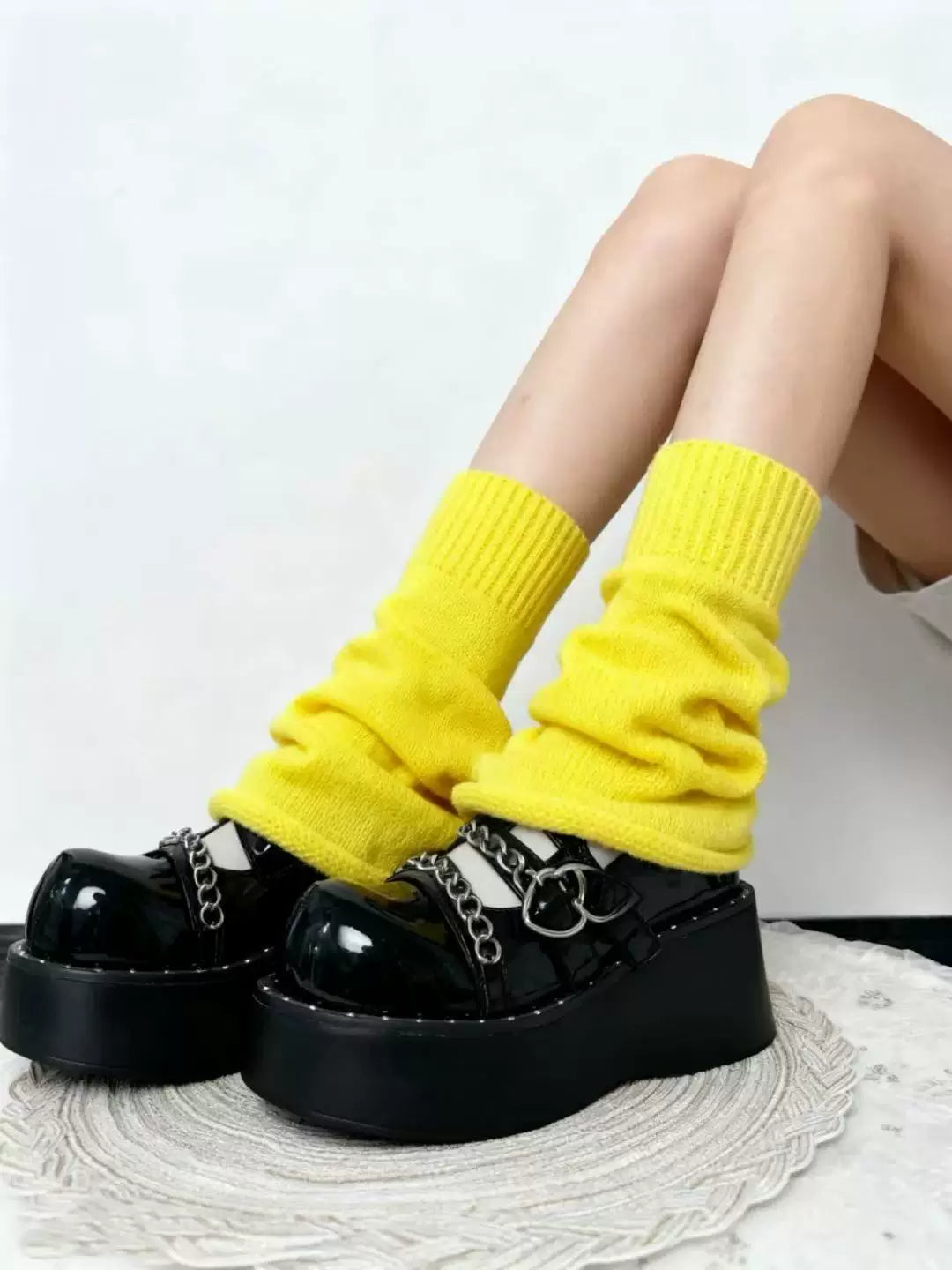 Black platform shoes styled with bright yellow knit leg warmers and folded cuffs.