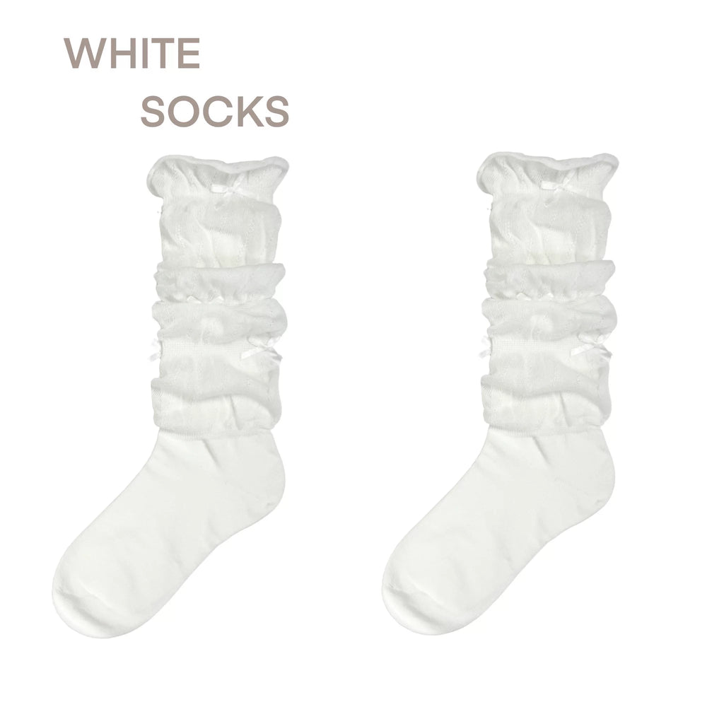 White gathered calf socks shown flat beside a black bow-trimmed styling example.