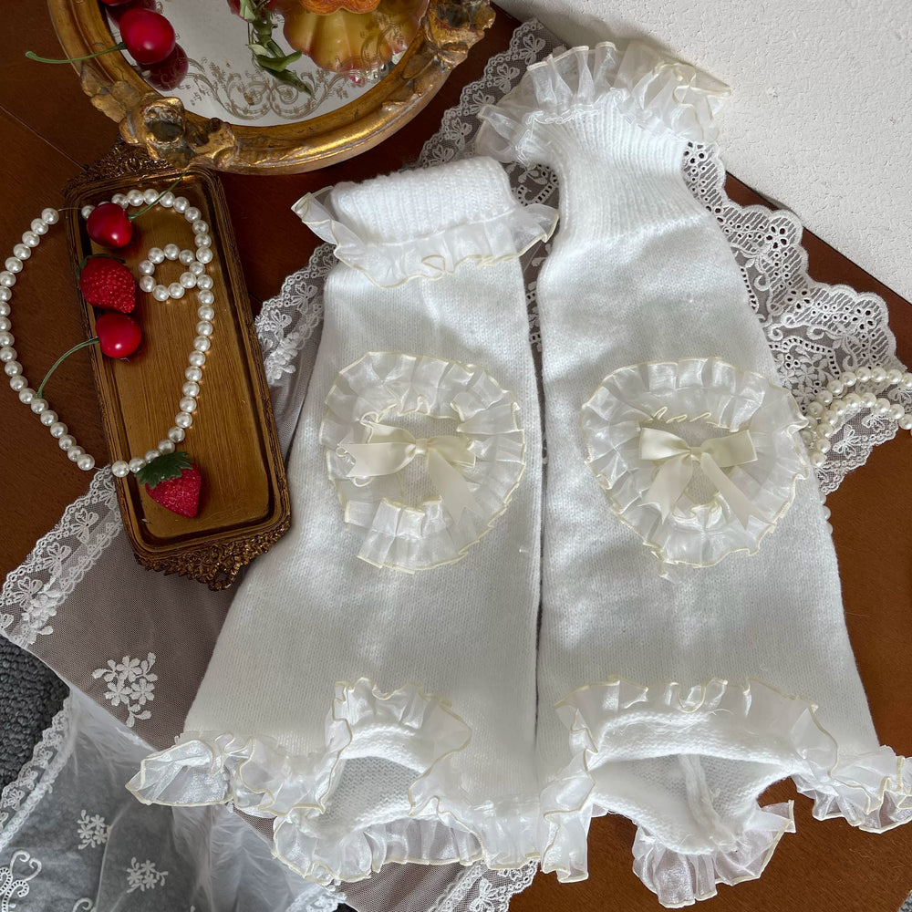 White dotted tights and ruffled sock layers styled with bows and pale shoes.