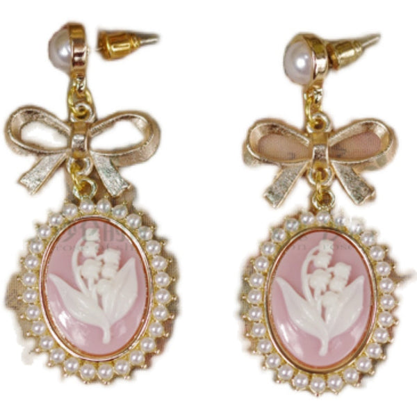 Pair of cameo Lolita earrings with bows, pearls and lily motif.