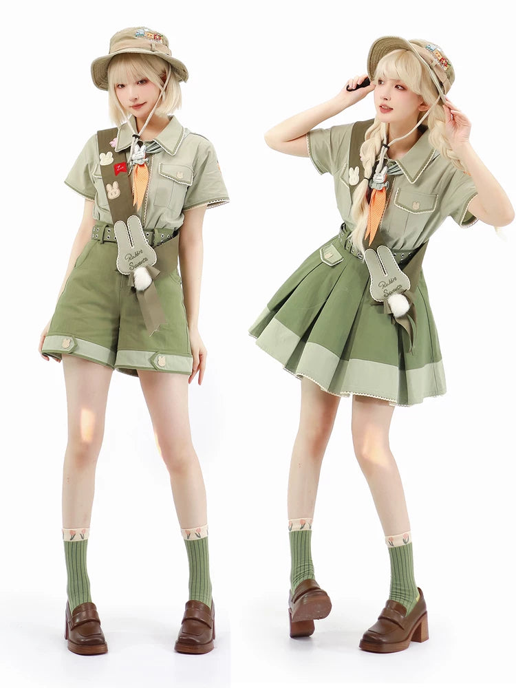 Khaki-green bunny-themed skirt and trouser outfit with neckerchief, belt and pom-pom accents.