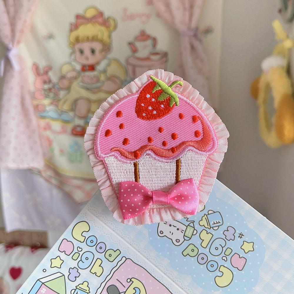 Pink strawberry cupcake embroidered brooch and hair clip with ruffled edging and a bow.
