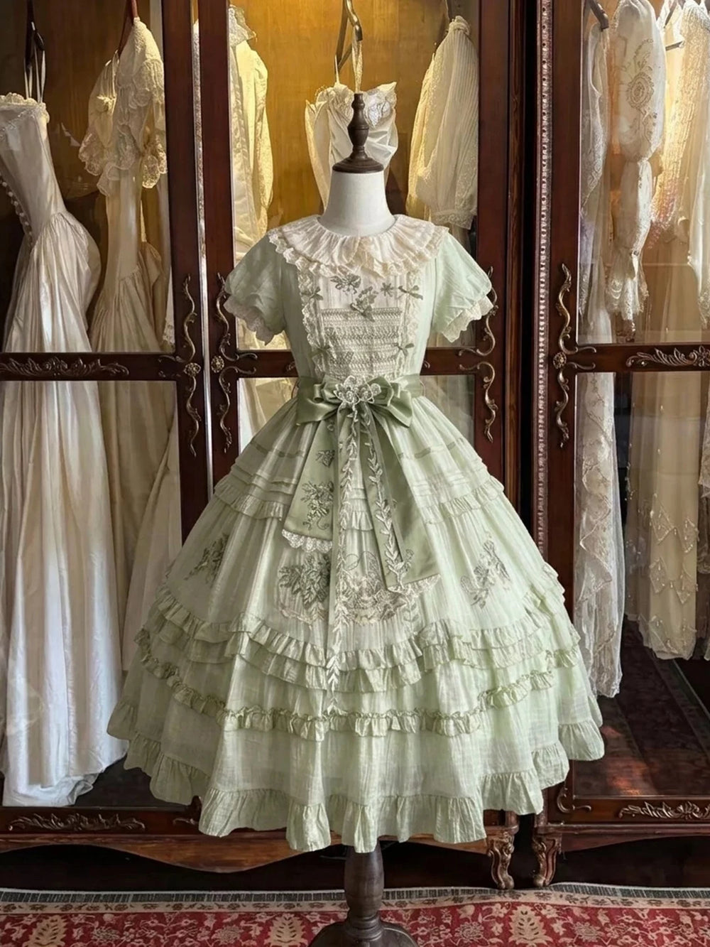 Creamy green embroidered OP dress displayed on a dress form