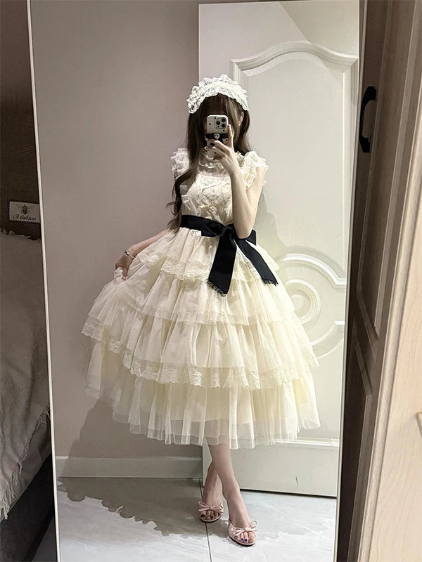 Front view of an ecru tiered lace OP with a black waist belt