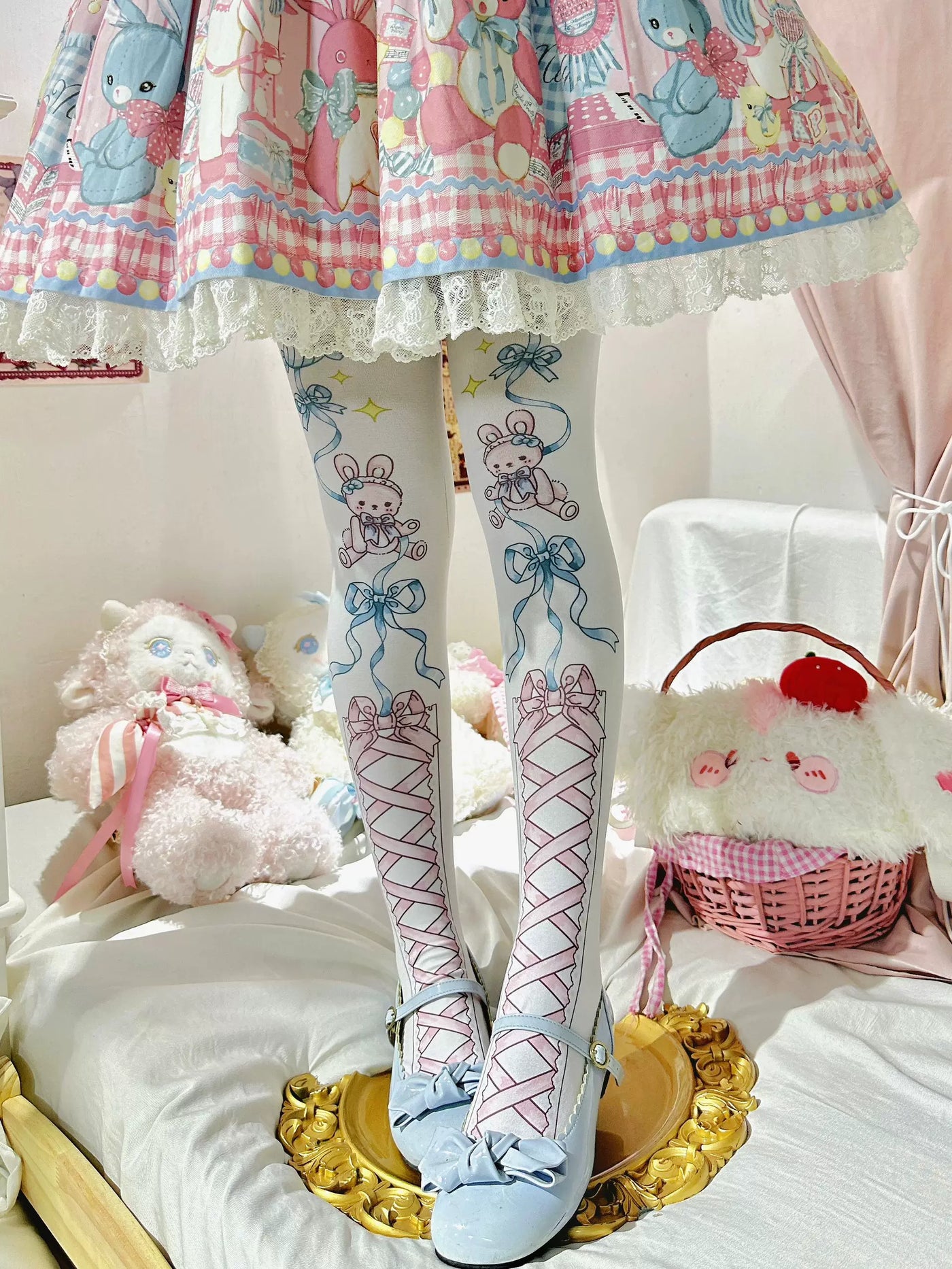 Pastel rabbit-and-ribbon tights worn with a printed skirt and pale blue shoes.