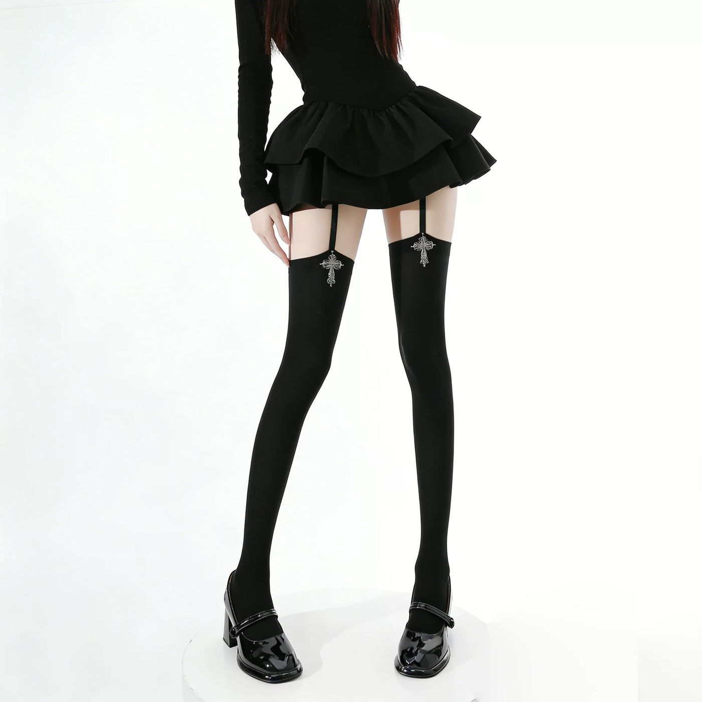 Black over-the-knee suspender stockings with cross motifs styled with patent Mary Jane shoes