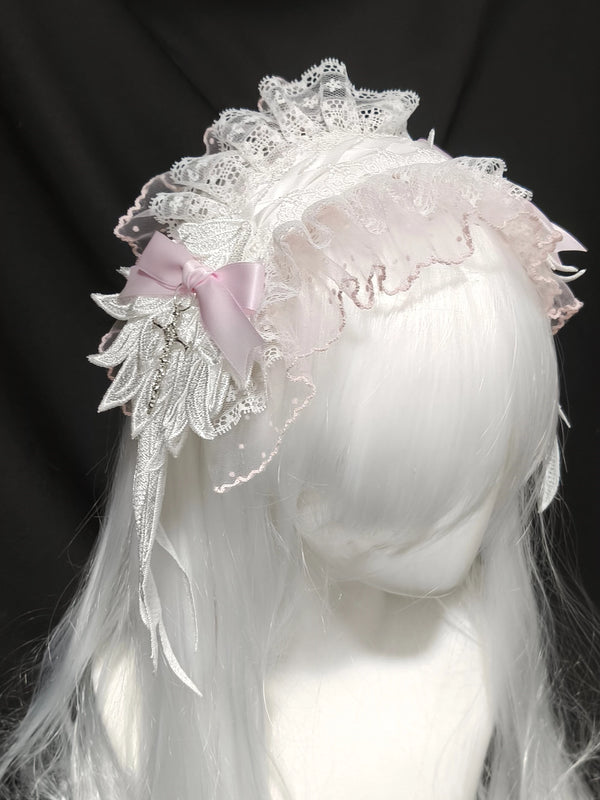 White lace angel hairband with a pink bow and hanging trim on a pale wig.