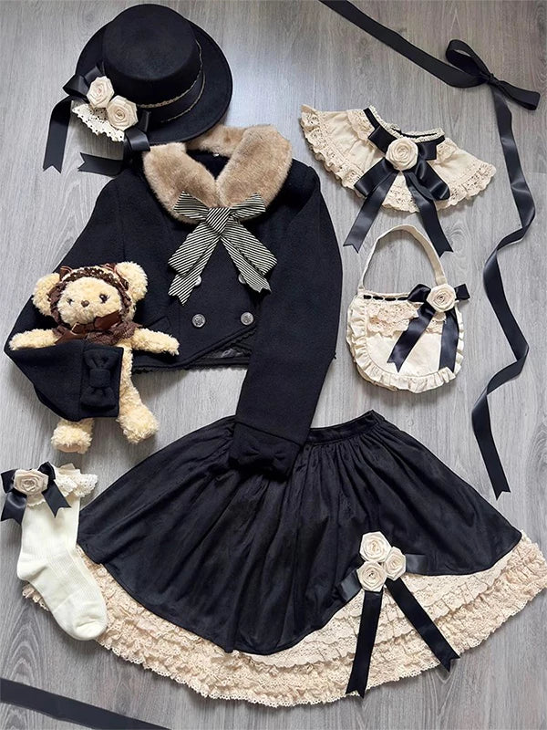 Black outerwear and skirt set with cream lace edging, bows, and a fur collar in a flat lay.