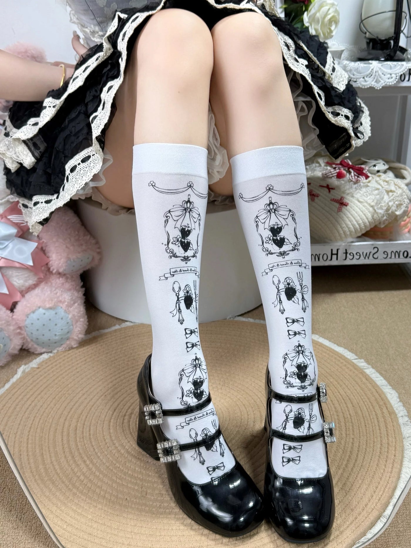 Black Fantasy Doll calf socks with repeating gold-toned cartoon print and bows